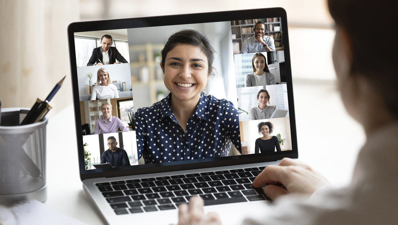 Image of online meeting via a laptop showing multiple attendees on screen