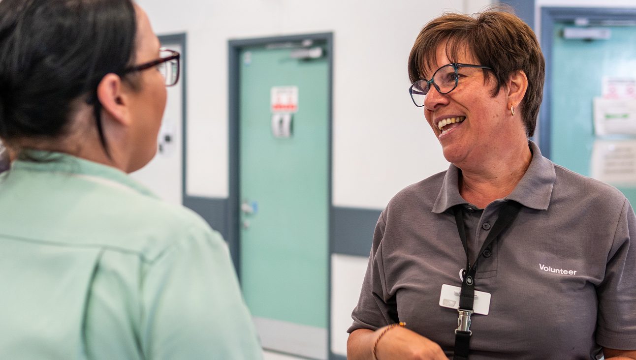 Female hospital worker with glasses helping someone