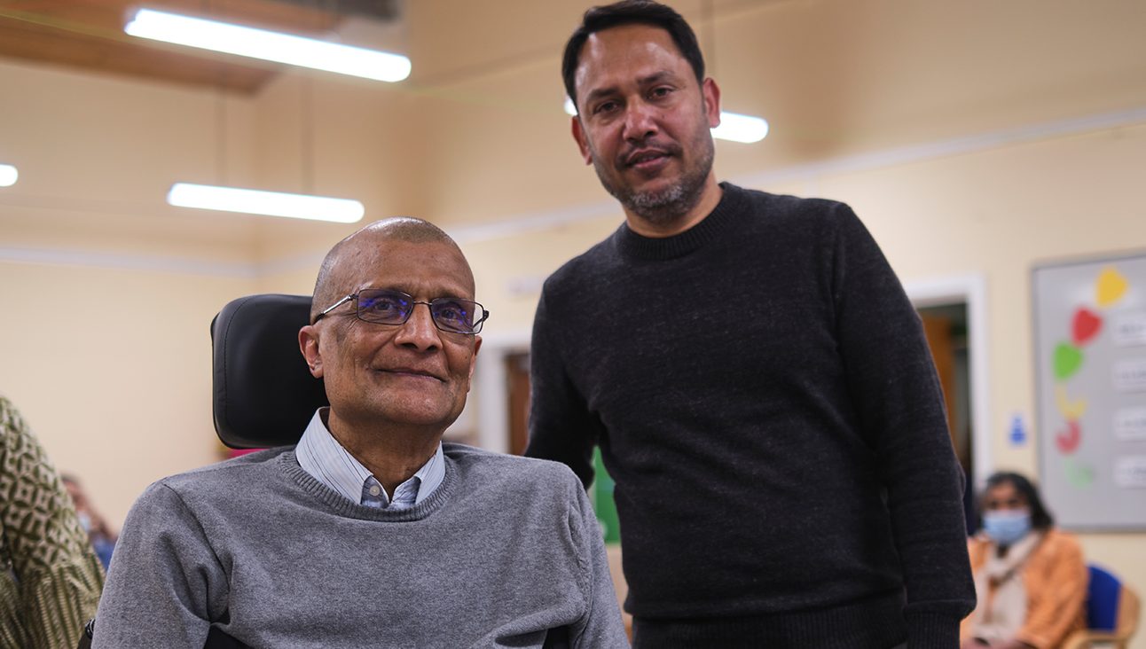 Older Asian man in a wheelchair and younger Asian man