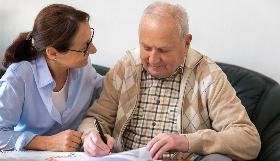 Woman Supporting Man to Fill Out Form