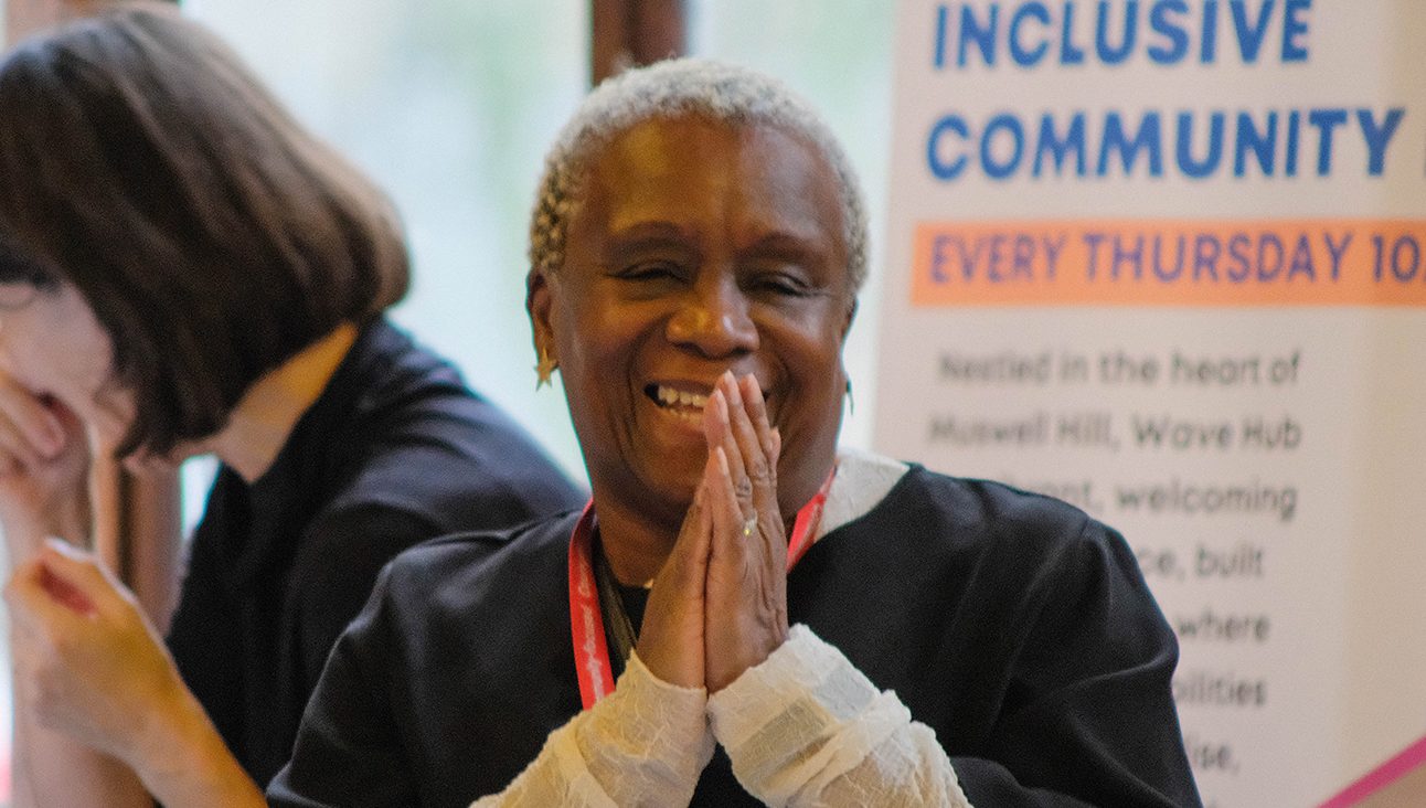 A black woman happy and smiling, looking at something off frame