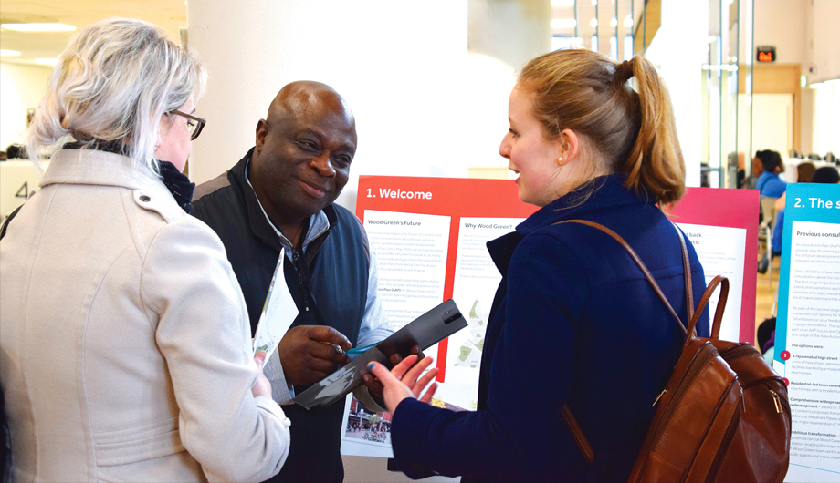 Black engagement manager engages two white women at consultation event
